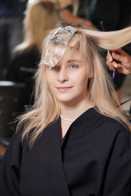 Cabeleireiro faz bouffant usando pente em mechas finas Técnica Shatush para clarear o cabelo