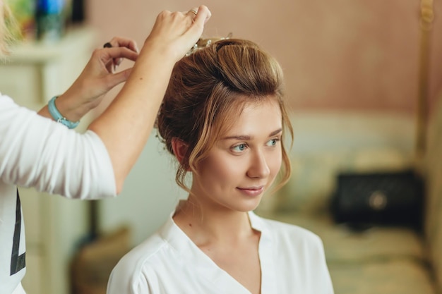 Cabeleireiro faz um penteado para uma jovem