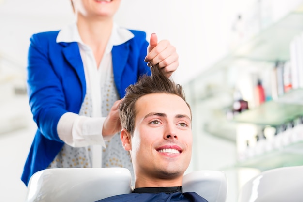 Cabeleireiro feminino lavando cabelo de homem em cabeleireiro