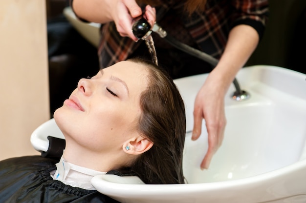 Cabeleireiro lavando cabelo de cliente