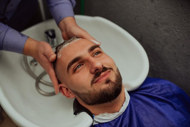 Cabeleireiro lavando o cabelo do cliente39 em uma barbearia Foco seletivo Foto de alta qualidade