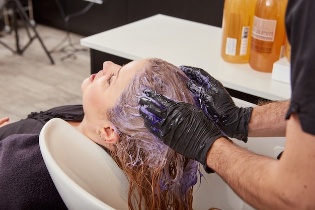 Cabeleireiro masculino tonificando o cabelo do cliente no salão