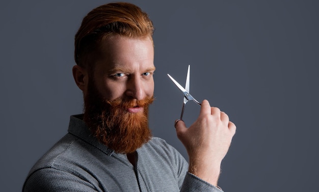 Cabeleireiro positivo com tesoura para fazer homem de corte de cabelo no estúdio de cabeleireiro