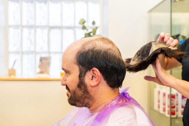 Cabeleireiro removendo a prótese capilar da cabeça de um homem