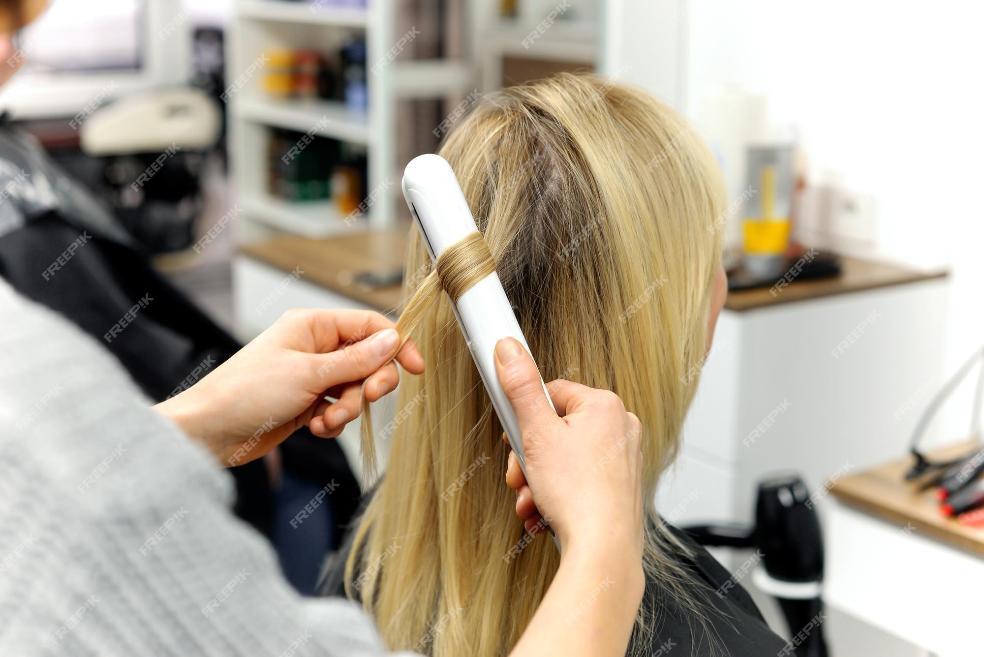 Cabeleireiro seca o cabelo com uma mulher de secador de cabelo no