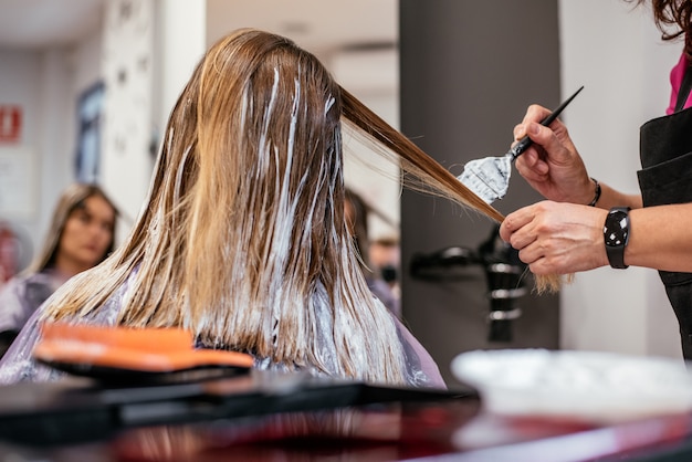 Cabeleireiro tingir o cabelo de uma mulher