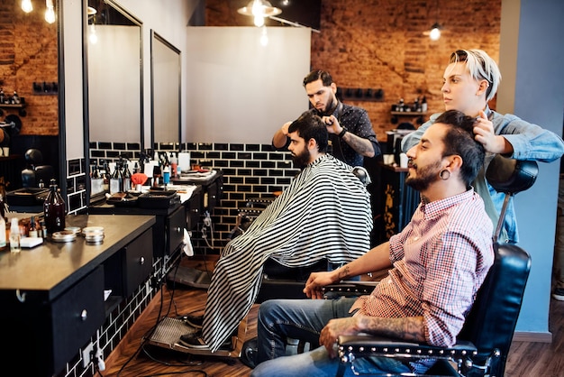 Foto cabeleireiros a trabalhar no cabelo dos clientes no salão