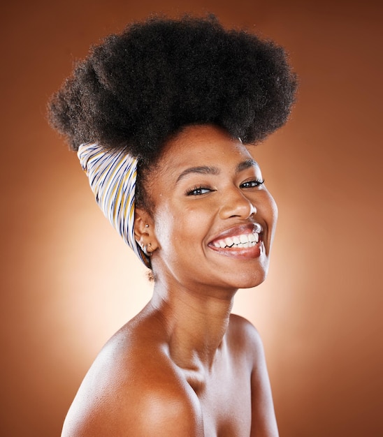 El cabello afro y el cuidado de la piel de la mujer negra brillan en el fondo del estudio en el cuidado de la salud, la dermatología facial o la cosmetología. Sonrisa de retrato o modelo de belleza feliz con pañuelo en la cabeza y maquillaje.