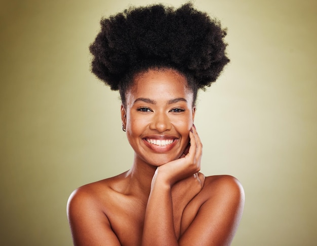 El cabello afro de la mujer negra o el cuidado de la piel brillan en el fondo del estudio para la promoción del cabello natural, el amor propio o el empoderamiento Sonrisa de retrato o modelo de belleza feliz con cosméticos de maquillaje en el fondo de la maqueta verde