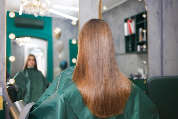 Cabello brillante y liso de una joven después de un procedimiento de laminación capilar. Cabello queratina y botox