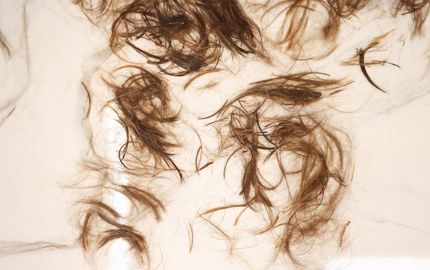 El cabello castaño se encuentra en el primer plano del piso blanco