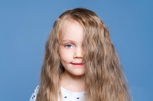 El cabello cubre la cara Niña con hermoso cabello rubio