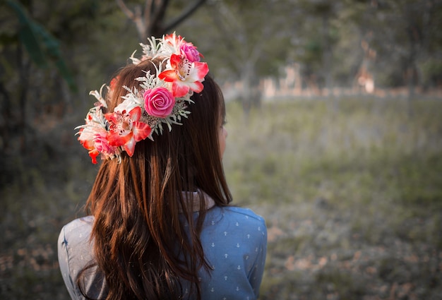 Cabello femenino con corona de flores en el paisaje de la naturaleza