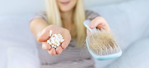 El cabello de una mujer se cae vitaminas Enfoque selectivo