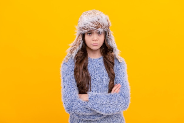 Cabelo comprido de criança séria com chapéu na moda da temporada de fundo amarelo