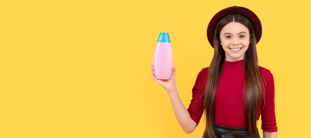 Cabelo comprido de menina adolescente feliz com loção corporal em gel de banho de fundo amarelo Banner de cabeçalho de cartaz de estúdio de cuidados com o cabelo de menina infantil com espaço de cópia