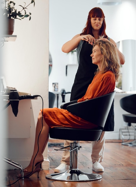 Foto cabelo de mulher e cadeira no cabeleireiro com sorriso no salão para beleza da moda ou corte de cabelo penteado sênior e esteticista trabalhando no cabelo do cliente ou patrono para maquiagem ou tendência