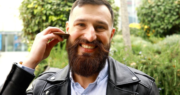 Cabelo de pente de homem atraente. Hipster cuida de sua barba.