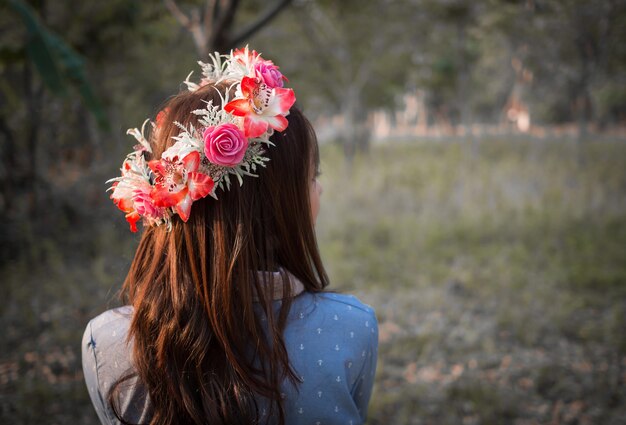 Cabelo feminino com coroa de flores na paisagem natural