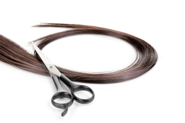 Cabelos castanhos brilhantes e tesouras de corte de cabelo isolados em branco