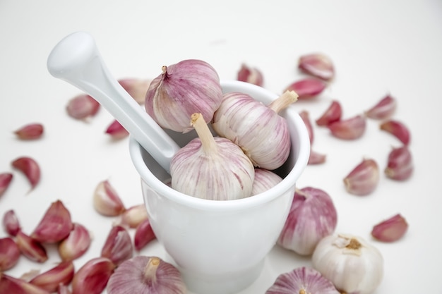 Cabeza de ajo sobre la mesa con molinillo de especias