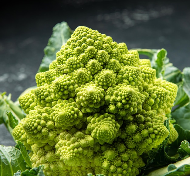 Cabeza de brócoli romanesco sobre una superficie de piedra oscura repollo cerrar secuencia de fibonacci para los amantes de las matemáticas