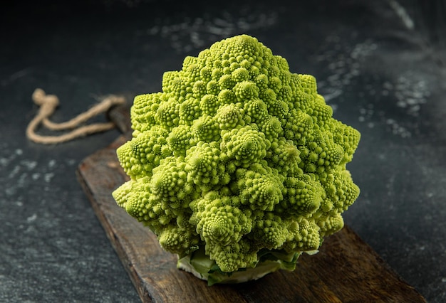 Cabeza de brócoli romanesco sobre una superficie de piedra oscura