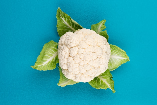 Foto una cabeza de coliflor fresca. alimentación saludable y vegetarianismo. fondo de color.