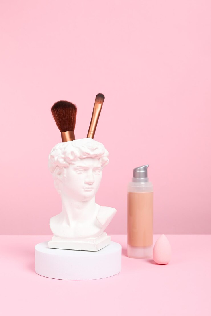 Cabeza de David con accesorios de maquillaje rosa.