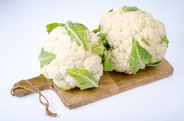 Cabeza fresca de coliflor en blanco.