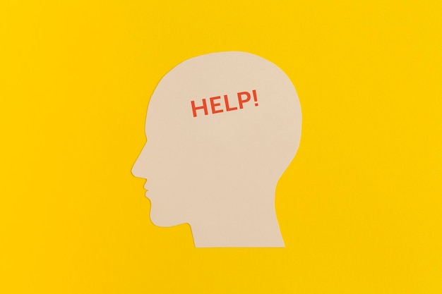 Cabeza humana con la palabra Ayuda sobre fondo amarillo