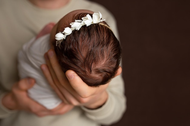 la cabeza de un recién nacido en la palma de su padre. pequeña cabeza de un recién nacido. niño en los brazos de un par