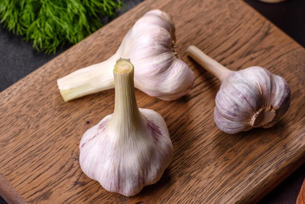 Cabezas de ajo blanco fresco sobre una tabla para cortar madera