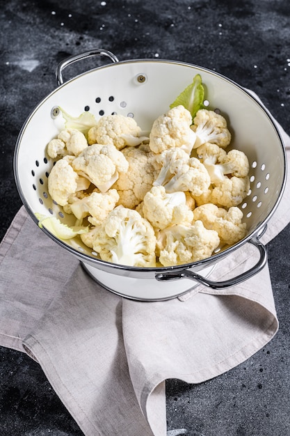 Cabezas blancas frescas limpiaron la coliflor en un colador