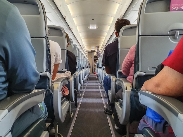 Foto cabina de un avión con pasajeros en asientos esperando para despegar