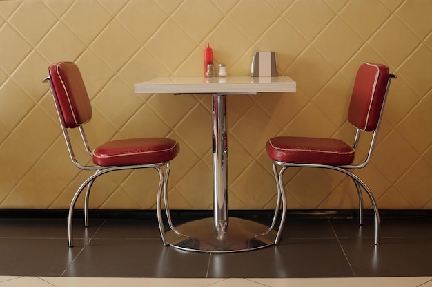 Cabina de comedor retro vacía con sillas tapicadas rojas