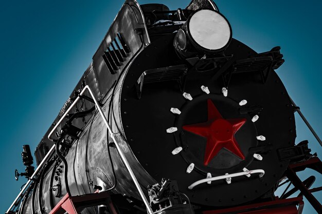 Foto cabina negra de una vieja locomotora de vapor soviética con estrella roja de cerca dramática y de contraste