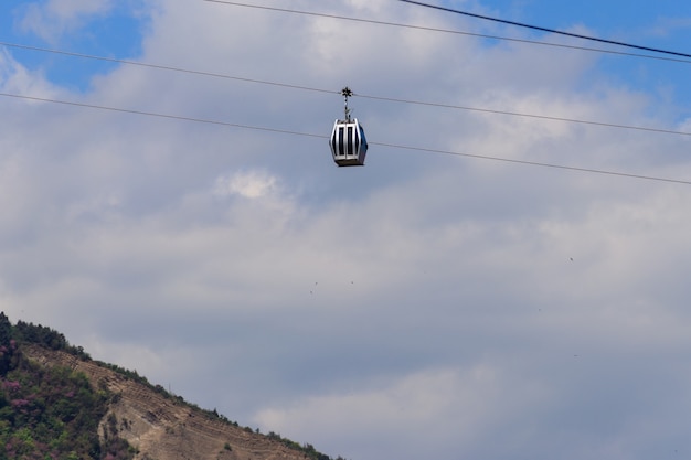 Cabina del teleférico contra el cielo azul. Teleférico en Tbilisi, Georgia