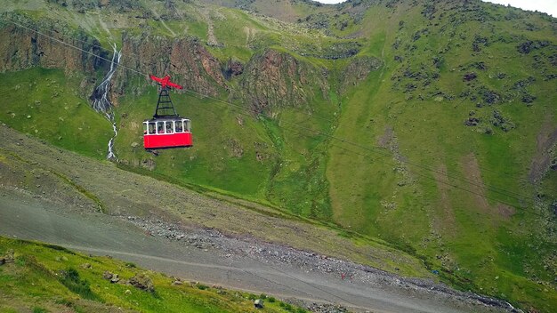 Cabina del teleférico rojo con el telón de fondo de las montañas