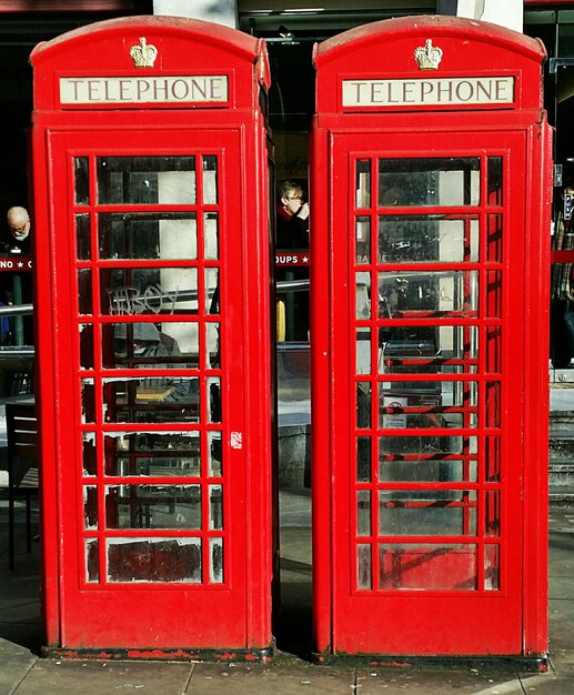 Cabina telefónica tradicional en la acera de la ciudad