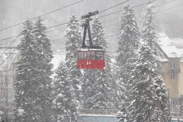 Cabina telescópica roja en las fuertes nevadas en las montañas del Cáucaso