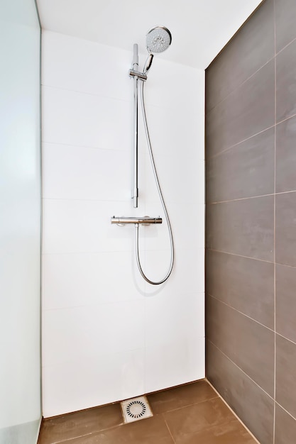 Cabine de duche em estilo minimalista com uma parede de azulejos castanhos