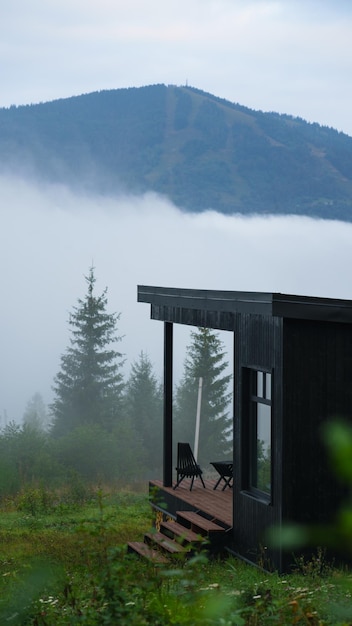 Cabine de madeira preta acima das nuvens nas montanhas dos Cárpatos na Ucrânia