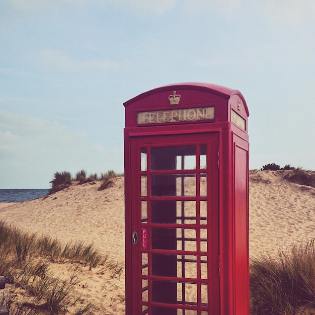 Foto cabine telefônica vermelha na praia