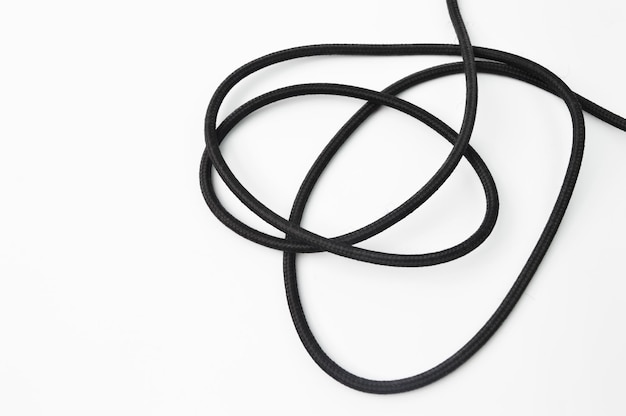 Un cable de alambre negro aislado sobre un fondo blanco