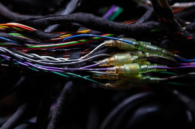 Un cable de alambres enmarañados de diferentes colores con conectores en el cableado eléctrico de la línea de Internet del automóvil en el trabajo del proveedor