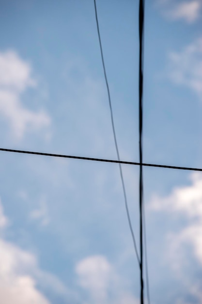 Foto cable de electricidad sobre un cielo azul con nubes