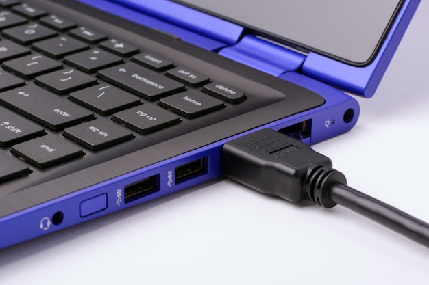 Cable HDMI enchufado en la moderna computadora portátil azul