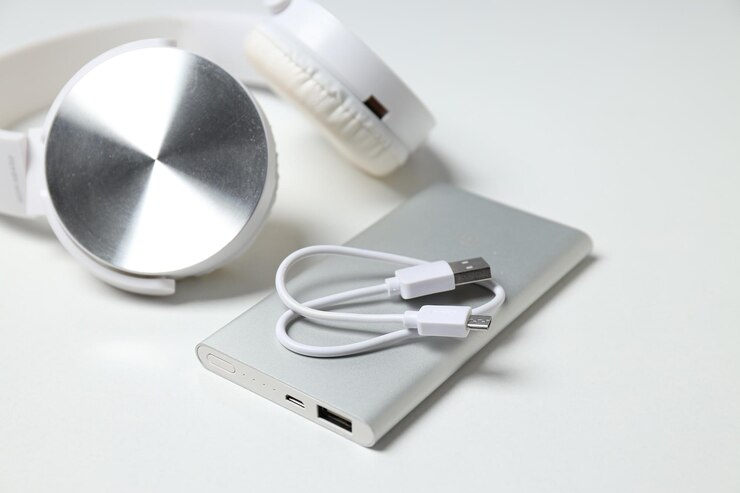 Cable Powerbank y auriculares sobre fondo blanco de cerca