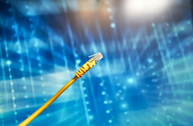 Foto cable de red amarillo con conector rj45 sobre fondo azul
